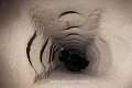 Grâce aux encoches taillées dans les parois et à l’étroitesse des conduits, il est assez facile de monter ou descendre dans les cheminées de communication qui atteignent jusqu’à 10 m de hauteur ; ville souterraine de Mazi (Cappadoce, Turquie). Cappadoce 
 Mazi 
 Turquie 
 ville souterraine 