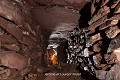 Le souterrain de Rath est un de ces ouvrages construits typiques de l’Irlande. Il s’agit ici d’une sorte de couloir composé de quatre tronçons à angle droit qui constituent autant de salles, et dont les parois de pierres sèches sont coiffées de larges dalles de couverture (comté de Cork, Irlande). Irlande 
 Rath 
 Vieux grès rouges 
 enceinte circulaire 
 fortification 
 ringfort 
 souterrain 
 souterrain aménagé 
 souterrain-refuge 