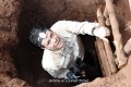 Ressortant du souterrain grâce à cette échelle artisanale, Laurent découvre les écoliers massés autour de l’orifice du puits ; environs d’Abomey (Bénin), mars 2014. Afrique de l'Ouest 
 Bénin 
 coulisses 
 fortification 
 souterrain 
 souterrain-refuge 