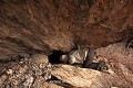 Une étroite ouverture délimitée par des dalles rapportées donne accès à la cavité qui s’étend sous le gros bloc rocheux  (Atakora, Bénin). Afrique de l'Ouest 
 Atacora 
 Bénin 
 abri sous roche 
 cache 
 grotte 
 guerre 